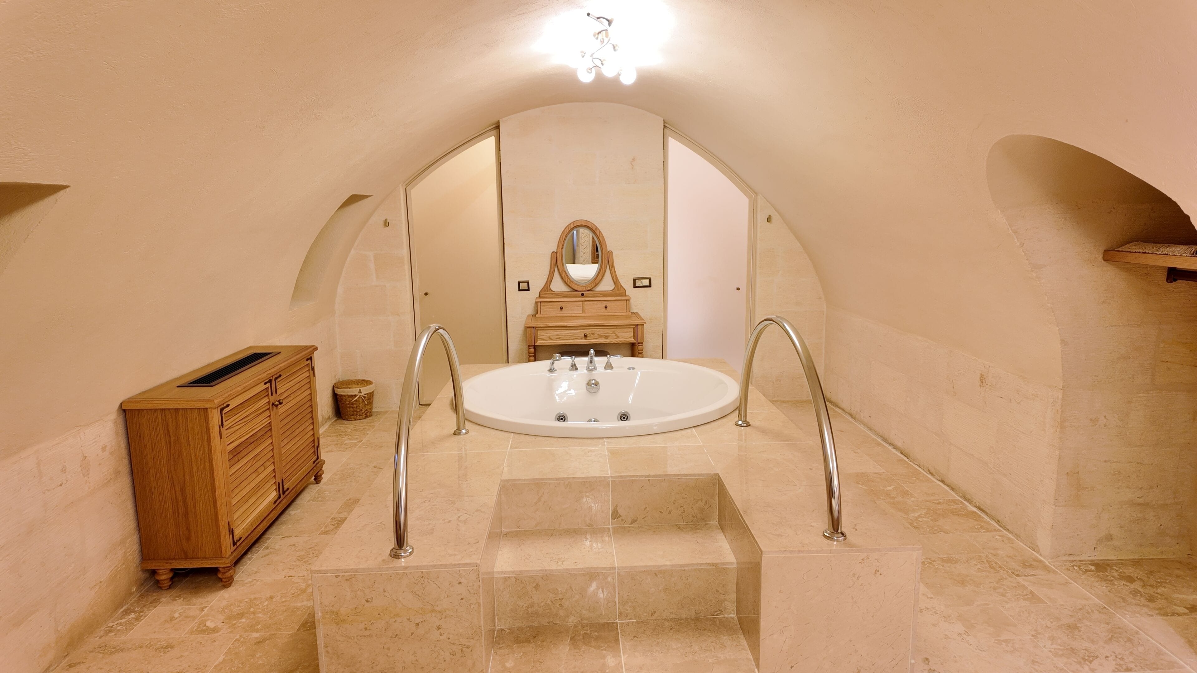 A bathroom with a freestanding bathtub, a wooden vanity, and a mirror above the sink.