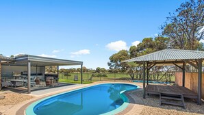 A swimming pool with a wooden deck, a covered seating area, and a fenced yard. - Seabreeze Acres ~ Maslin Beach - Seabreeze Acres = Coastal Serenity! (Maslin Beach)