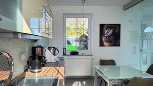 Una cocina moderna con comedor, una ventana con vistas y un cuadro en la pared.