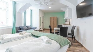 Una habitación de hotel moderna con una cama grande, un escritorio y un televisor.