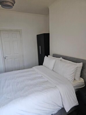 Un dormitorio con cama, armario y puerta.