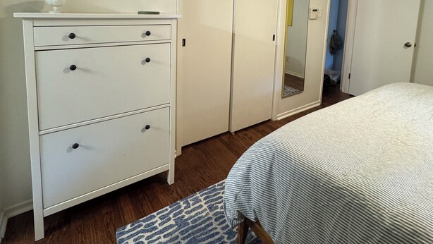 A bedroom with a bed, a dresser, a wardrobe, and a framed map on the wall. - Charming Raleigh Retreat (Raleigh)