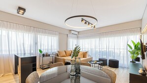 Uma sala de estar moderna com uma mesa de jantar redonda, sofás e uma televisão.