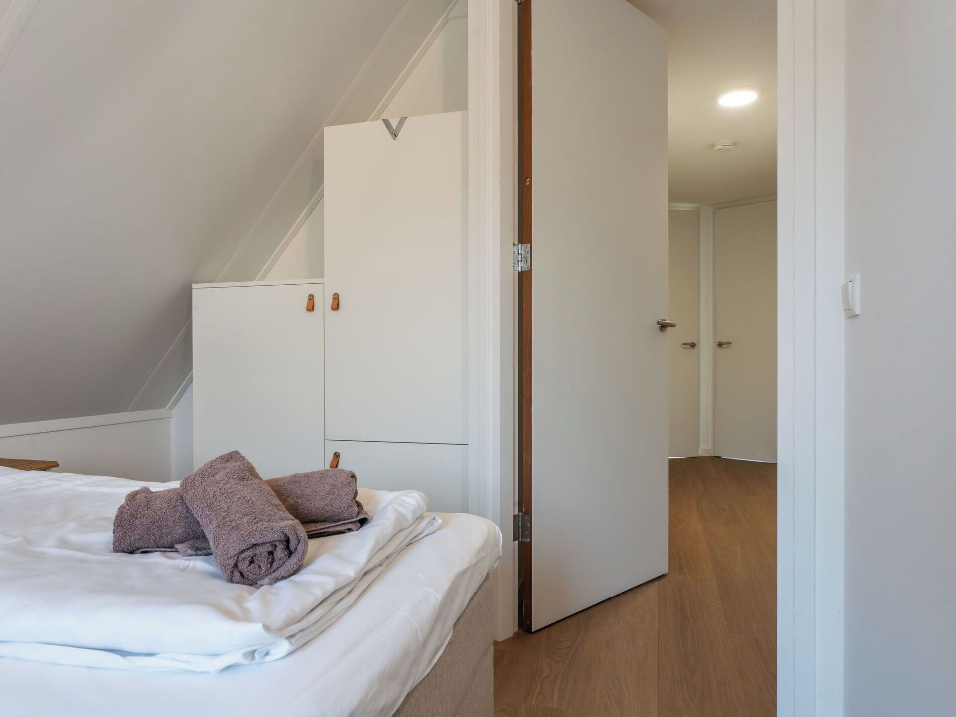 Una camera da letto con un letto, un armadio e una porta che dà su un'altra stanza.