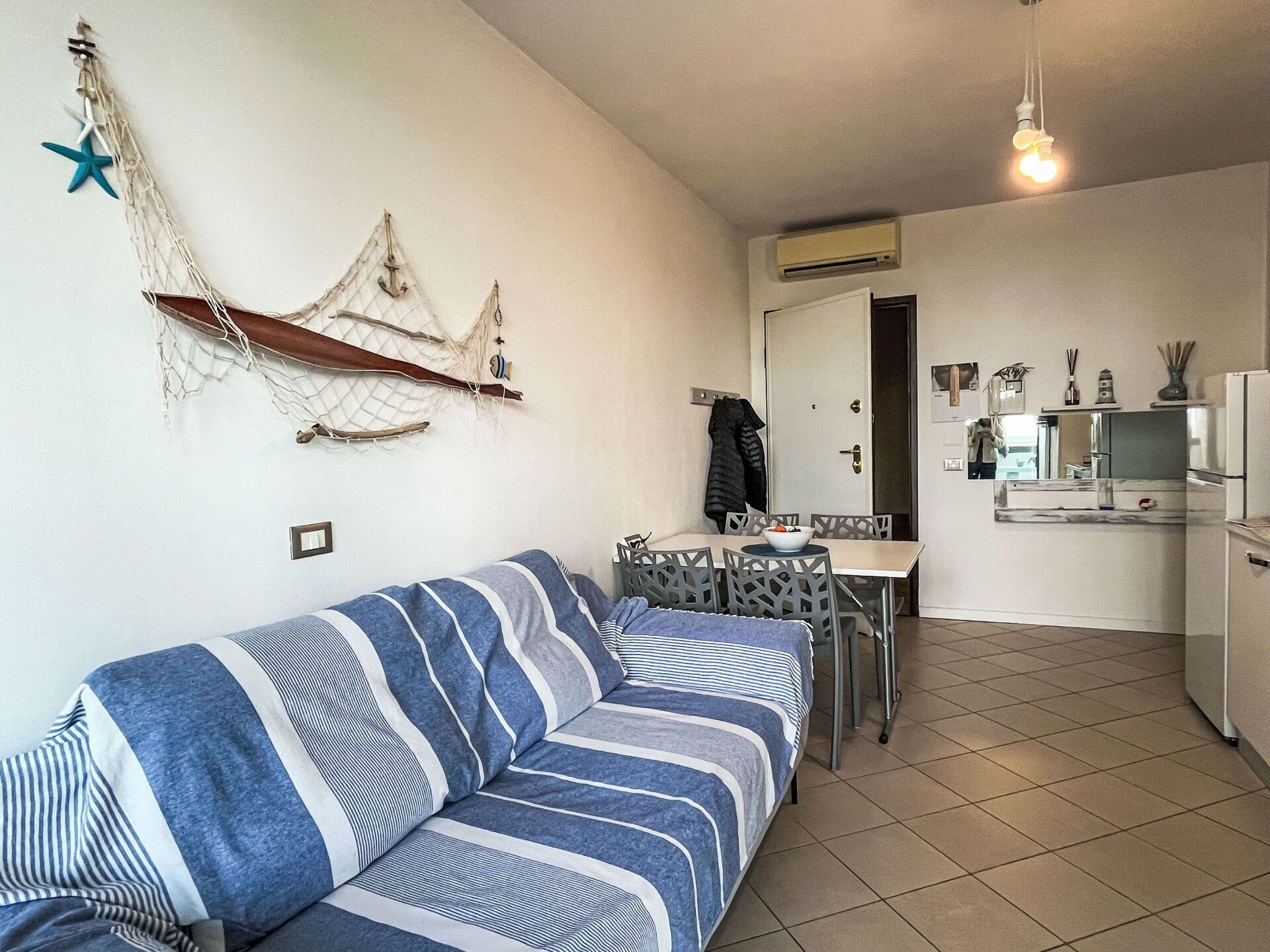 Un espace de vie compact comprenant un canapé, une table à manger et un coin cuisine.