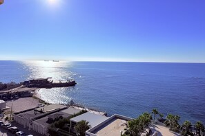 Une vue sur la côte, avec une jetée, des bâtiments et un ciel dégagé.