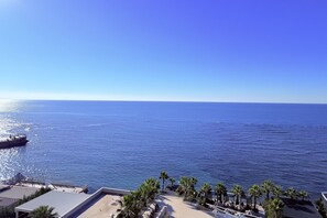 A coastal hotel with a view of the sea, palm trees, and a deck area. - Beachfront Apartment In Durres 072 (Durrës)