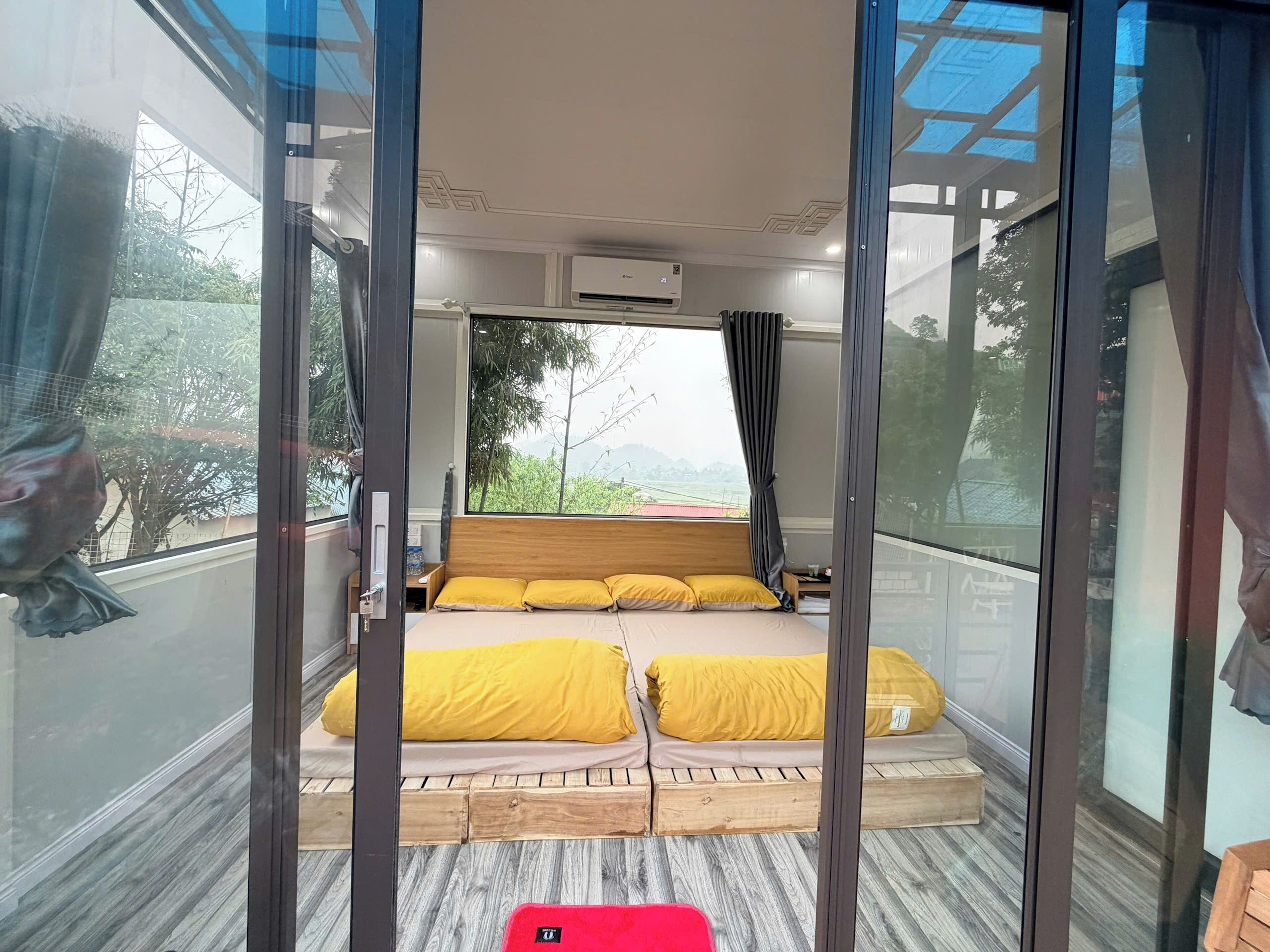 A room with a bed, a nightstand, and a window with curtains.