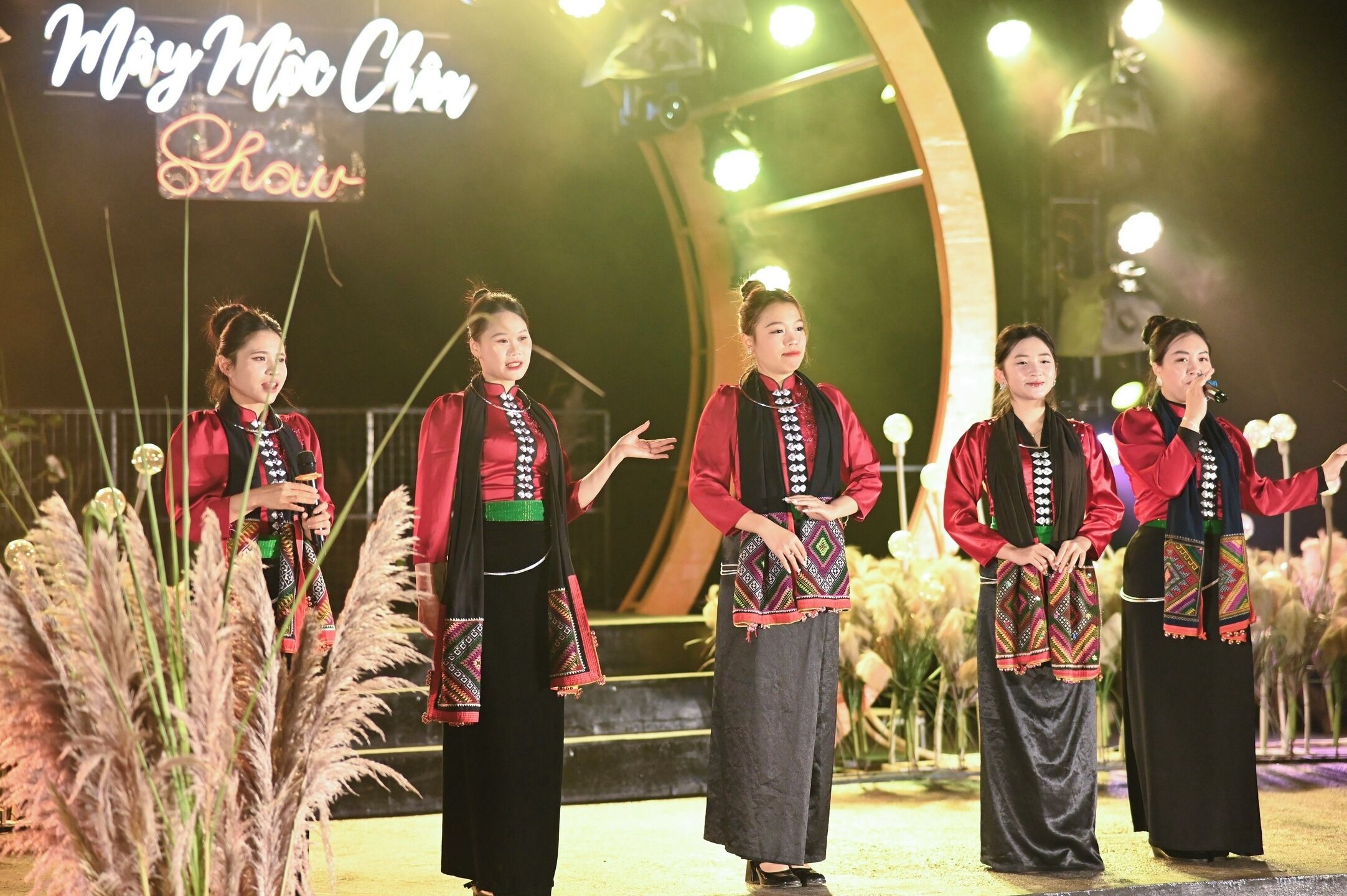 Een groep artiesten op een podium met een bord waarop staat: May Miao Chuan Lai.