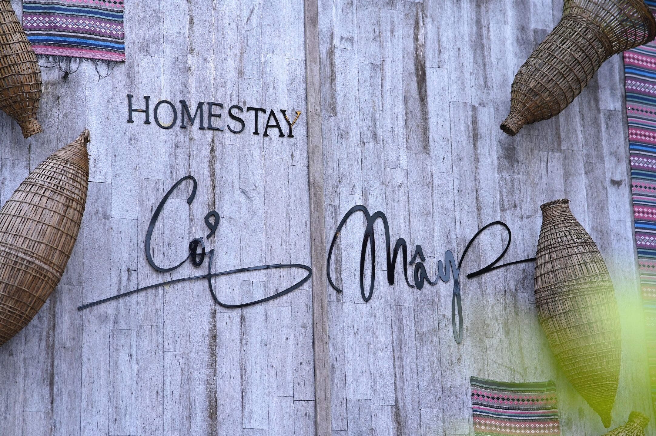 A wooden wall with the words "HOMESTAY" and a signature.