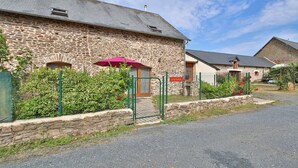 A stone building with a metal gate and a sign that reads 'LAITERIE'.