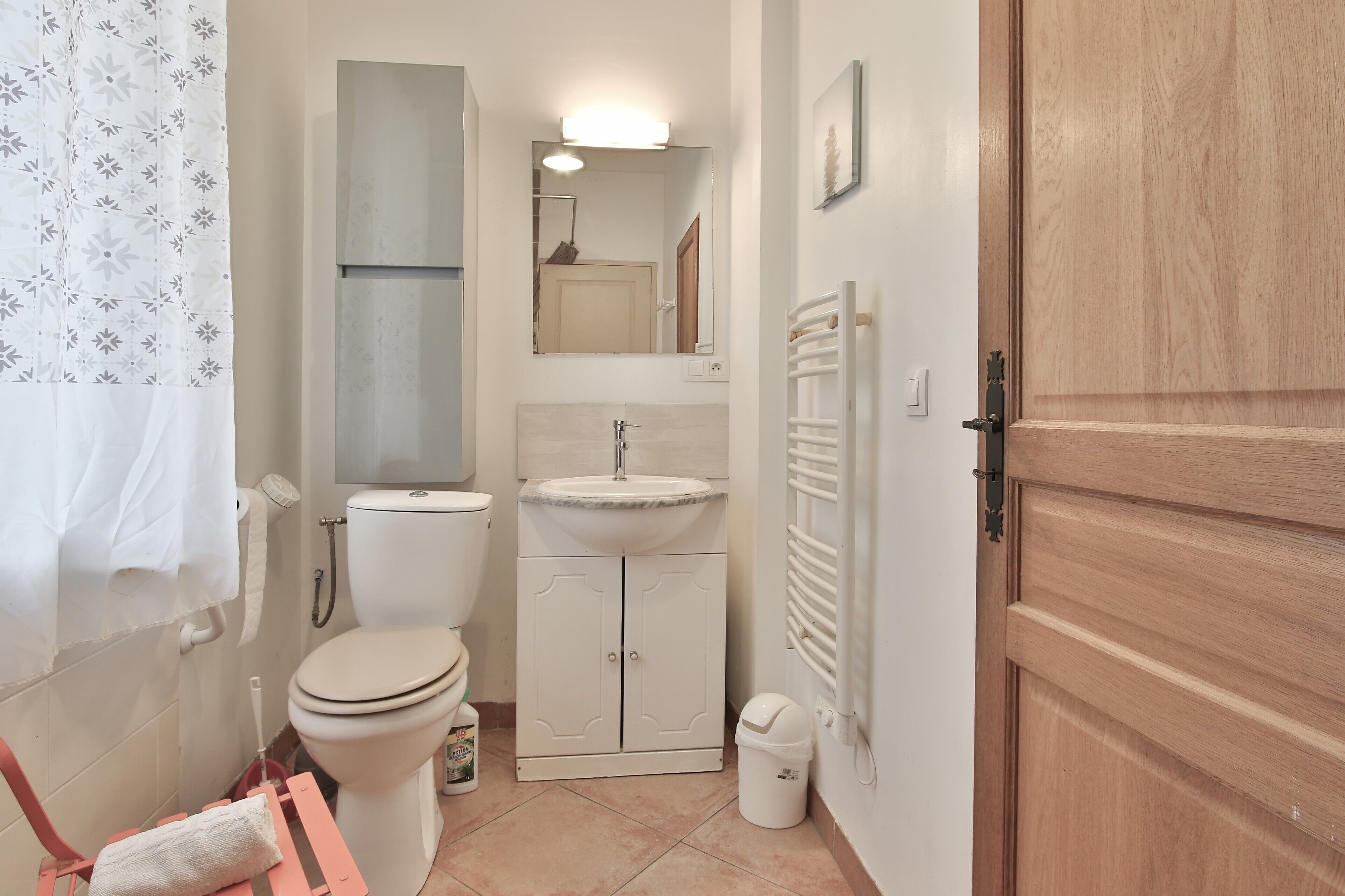 Une salle de bain équipée de toilettes, d’un lavabo, d’un miroir et d’un rideau de douche.