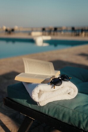 A lounge chair with a towel and sunglasses, and an open book on it. - Roushan Resort  (Mirbat)