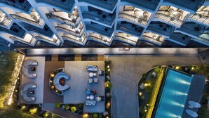 An aerial view of a hotel with multiple floors, outdoor seating areas, and a swimming pool. - Langyun Garden Hotel (Guilin)