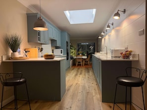 A modern kitchen with a central island, pendant lighting, and a skylight. - Coastal Comfort for 6, Felpham Beach (Felpham)