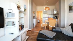 Een compact verblijf met een kitchenette, een eethoek en een zithoek.
