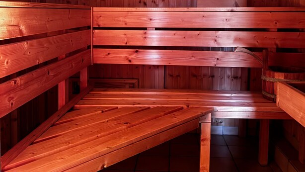 Een sauna met houten banken en een betegelde vloer.