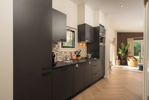 Enjoy a luxurious holiday home for 5 persons in the wooded nature of the Veluwe, complete with modern amenities, air conditioning, and a stylish pergola for optimal comfort. Additionally, you can fully unwind in the delightful private hot tub, perfec