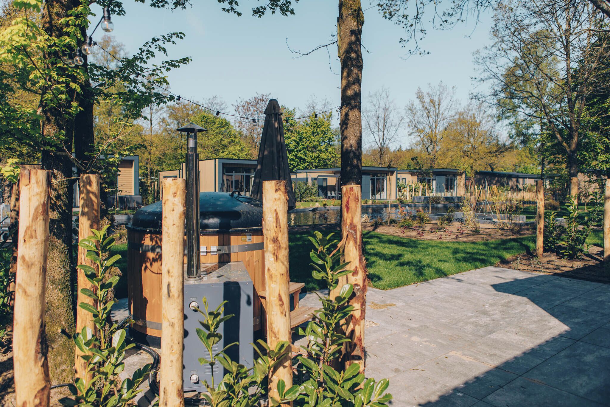 Ein Garten mit Grill, Holzzaun und gepflasterter Terrasse.