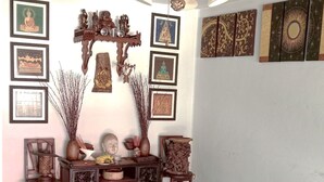 A room with a ceiling fan, a wooden cabinet with drawers, and various framed artworks on the walls. - OhoWowGood Home Stay Chiangmai room 101 (Tambon Fa Ham)