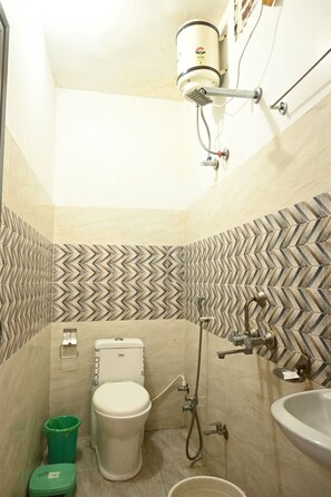 A bathroom with a toilet, sink, and shower. - The Kashi Palace (Varanasi)