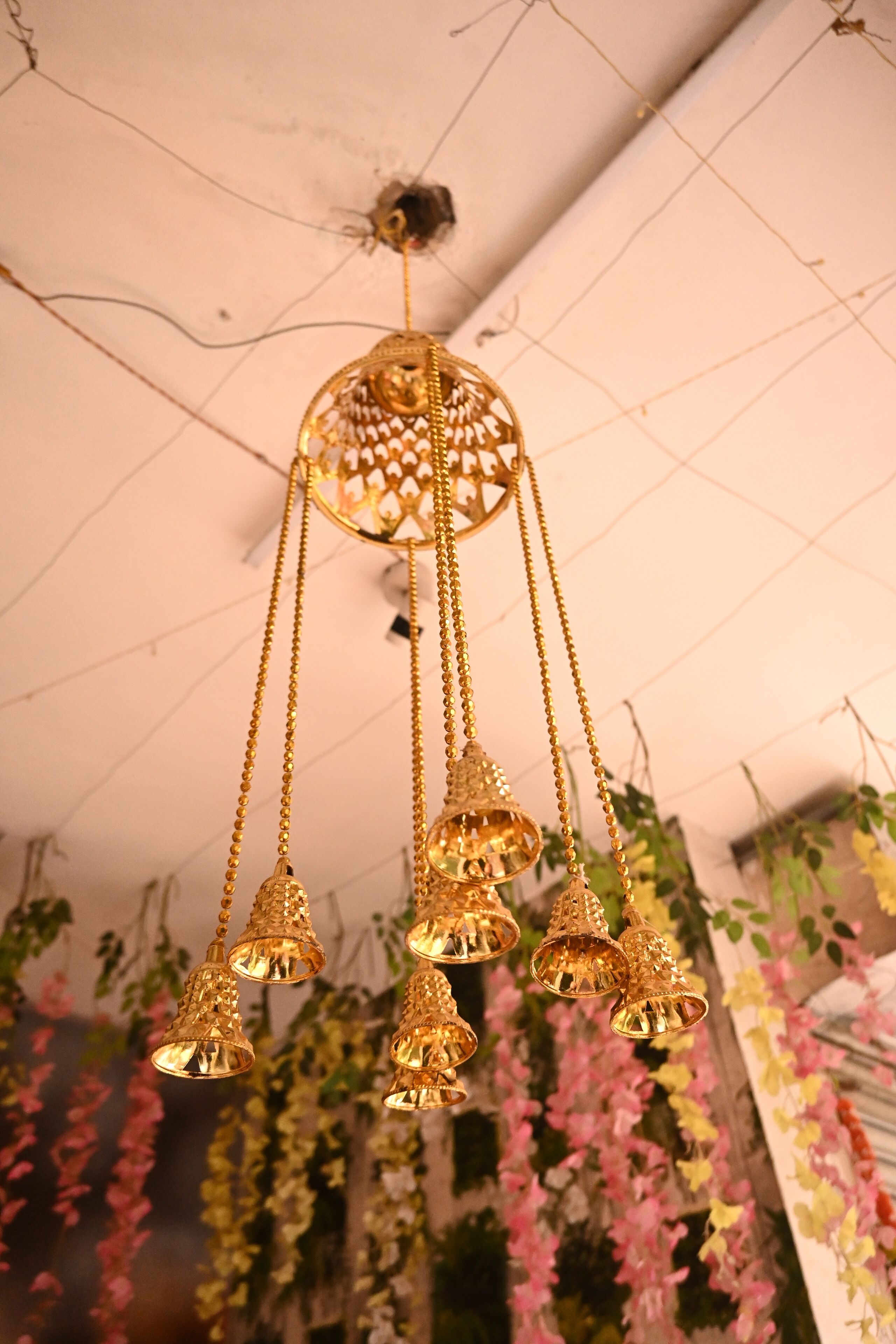 A decorative hanging with multiple golden bells and a central circular ornament.