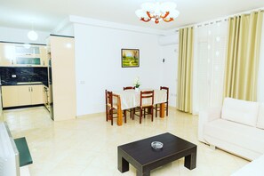 A modern living room with a dining area, a sofa, and a coffee table. - Enjoyable 2-bedroom apartment with AC in vibrant Vlora (Vlora)