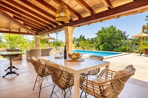 An outdoor patio with a pool, wicker furniture, and a table with fruit. - Marina Mala Garba 5 people pool wifi (Pollensa / Pollença)