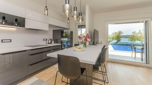 A modern kitchen with a large island, stainless steel appliances, and pendant lighting. - Apartment Adriatic With Pool (Vodice)