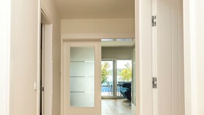 A hallway with a wooden floor, a patterned rug, and white doors leading to other rooms. - Apartment Adriatic With Pool (Vodice)