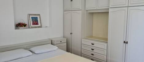 A bedroom with a bed, nightstands, a dresser, and a wardrobe.