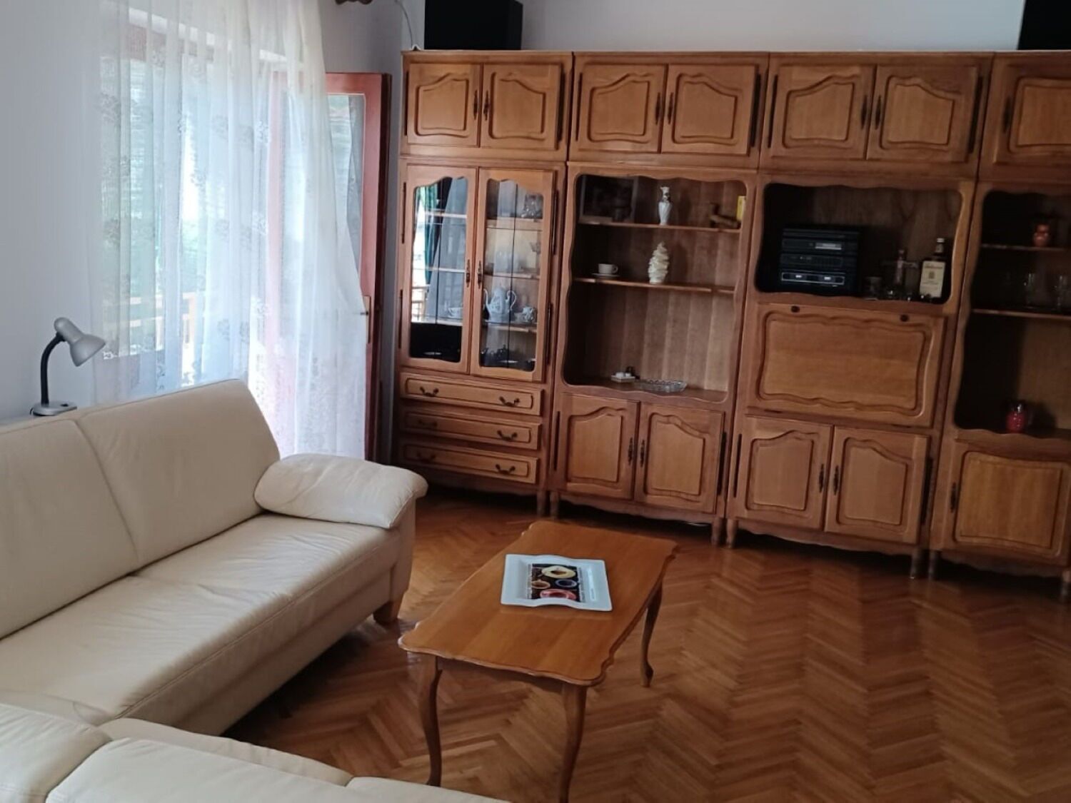 A living room with a sofa, wooden cabinets, and a coffee table.