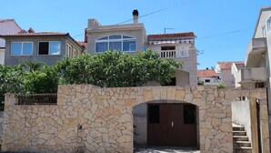 A stone wall with a gate and a small archway leading to a building. - Apartments Brti (Supetar)