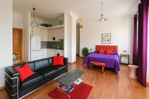 A compact living space with a kitchenette, a sofa, a bed, and a dining area. - Ole Málaga - Superior (Malaga)