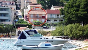 A boat with the registration TG-3124 docked near a waterfront with buildings in the background. - Apartments Andelka (Marina)