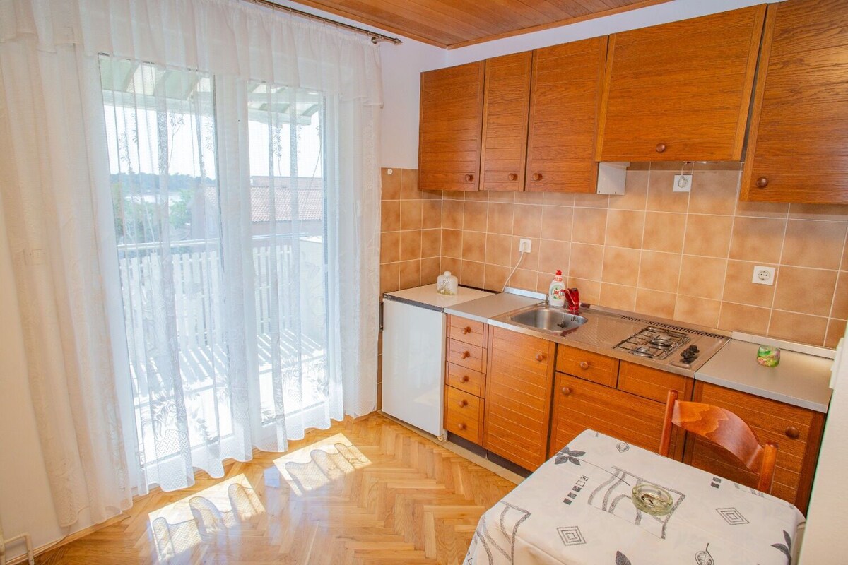 A kitchen with wooden cabinets, a sink, and a stove.