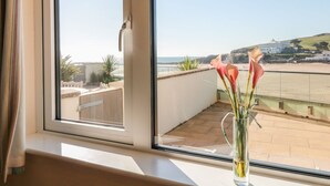 Un balcón con vistas despejadas a la playa y un edificio a lo lejos.