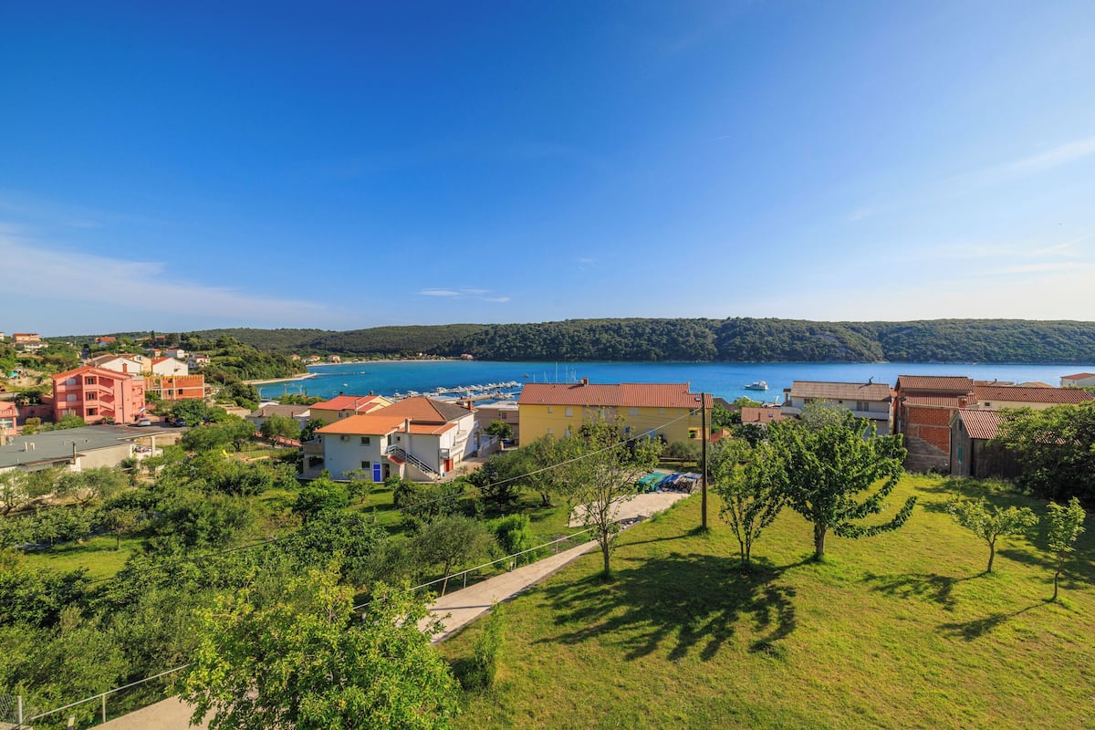 A coastal residential area with houses, a marina, and a clear blue sky.