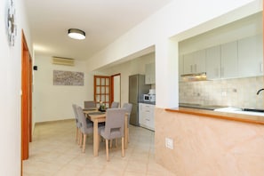 A modern kitchen with white cabinets, a stainless steel refrigerator, and a microwave. - Apartment Ren (Rab)