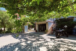 A motorcycle parked in front of a building with a staircase leading to the entrance. - Apartments Ivan (Rab)