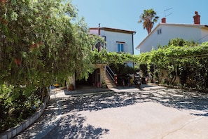 A residential area with a house, a staircase, and a clear sky. - Apartments Ivan (Rab)