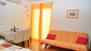 A cozy room with a sofa, a dining table, and a bed. - Apartments Ivi (Makarska)