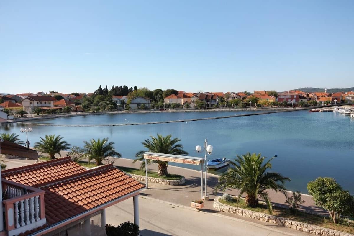 A waterfront view with a sign indicating 'Karolovac' and 'Hotel Toni'.