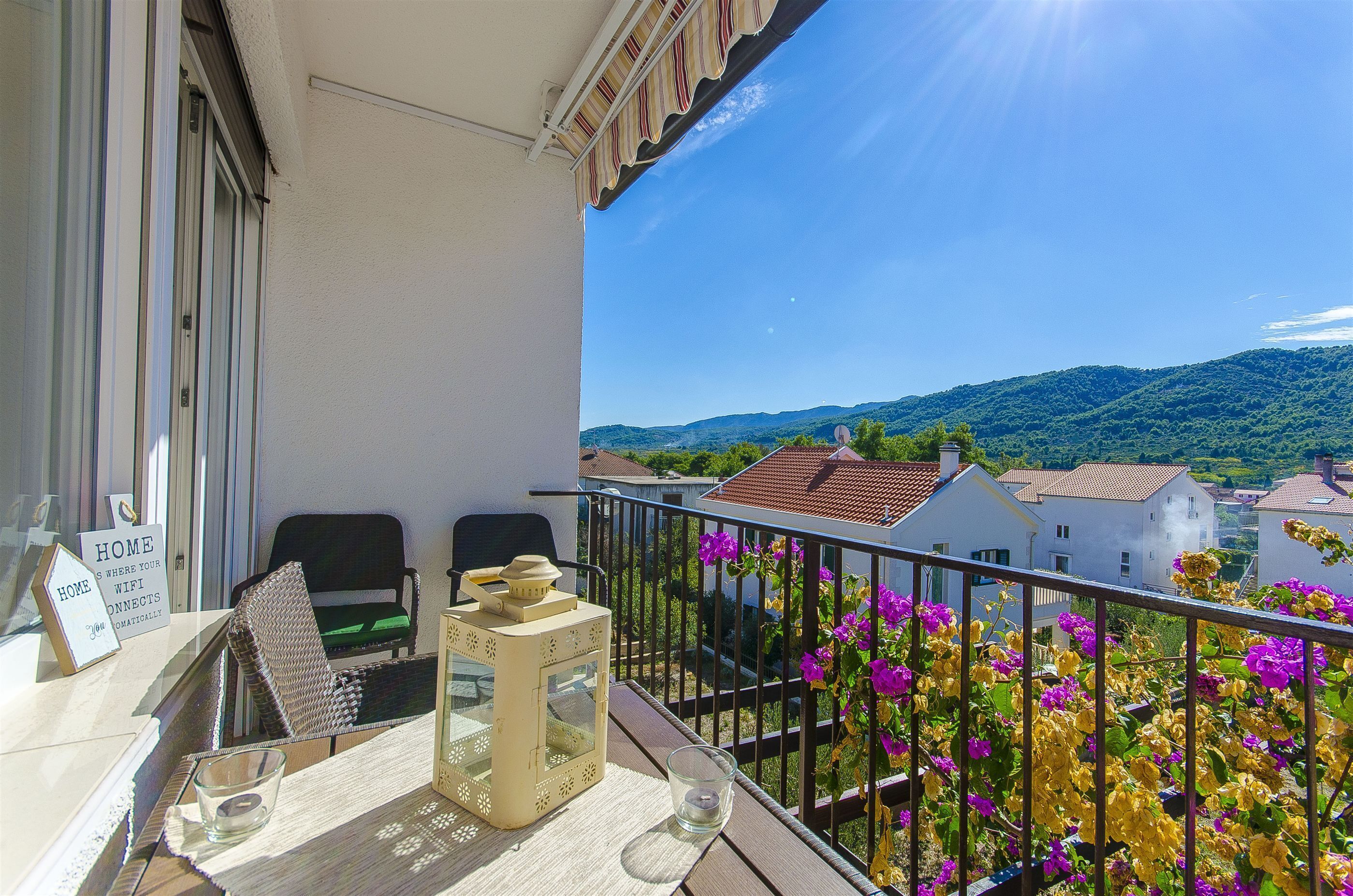 A balcony with a table, chairs, and a sign indicating home WiFi.
