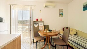 Un comedor con una mesa redonda, sillas y vistas al exterior a través de un ventanal.