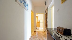 Un pasillo con un aparador de madera, un copete y un cuadro en la pared.