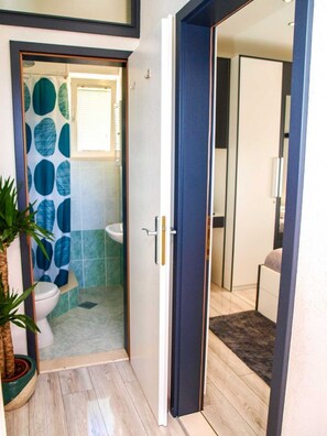 Een badkamer met een douche, toilet en wastafel.