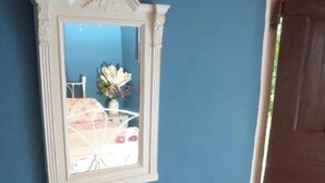 A small table with a mirror above it, a wooden chair, and two bowls on the table. - House Mare (Postira)