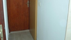 A hallway with a wooden door and a light blue wall. - House Mare (Postira)