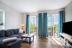 Ein modernes Wohnzimmer mit einer Couch, einem Couchtisch und einer TV-Konsole.